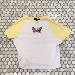 White and yellow top with short sleeves and a vintage pink and black butterfly